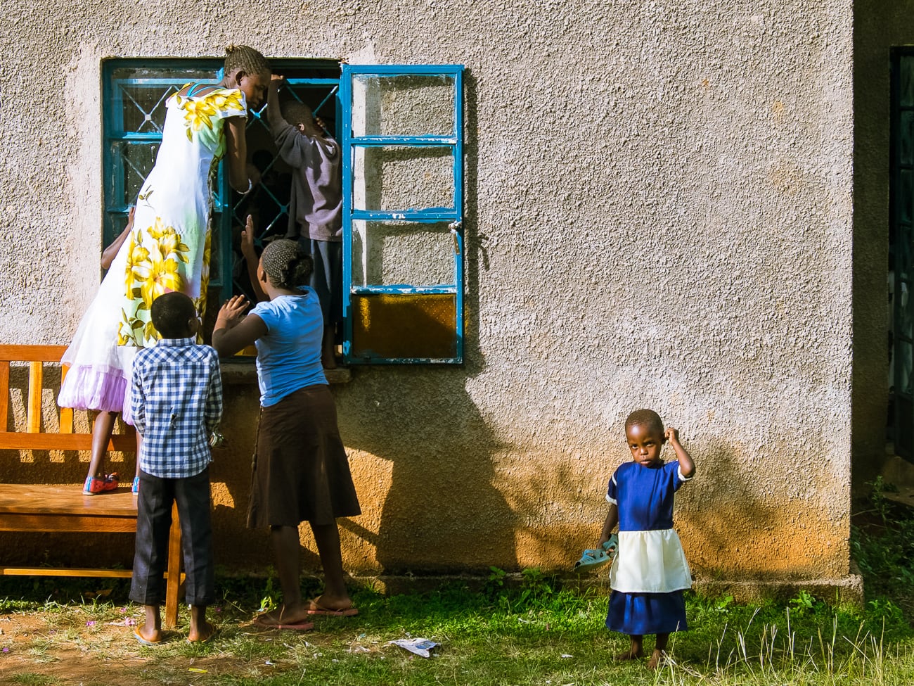 Children peeking in through a window at a church wedding in Kima, Kenya