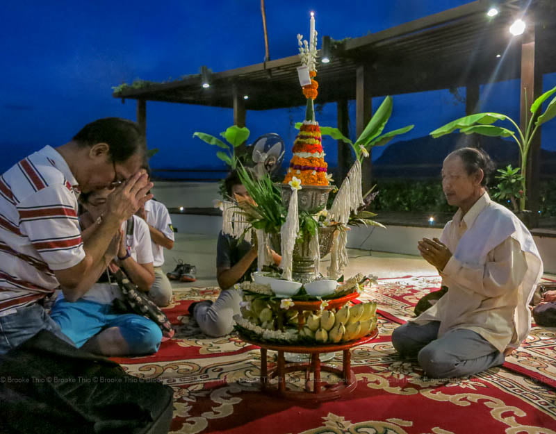 People sitting around a marigold pyramid during a Baci ceremony in Luang Prabang, Laos.