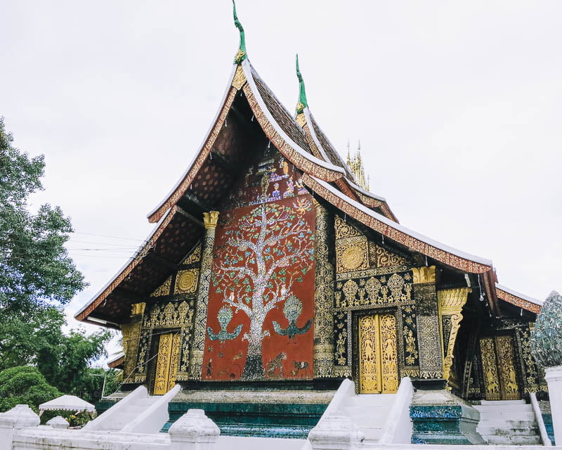 A large, intricate mosaic of jeweled colors on a temple wall at Wat Xieng Thong, Luang Prabang