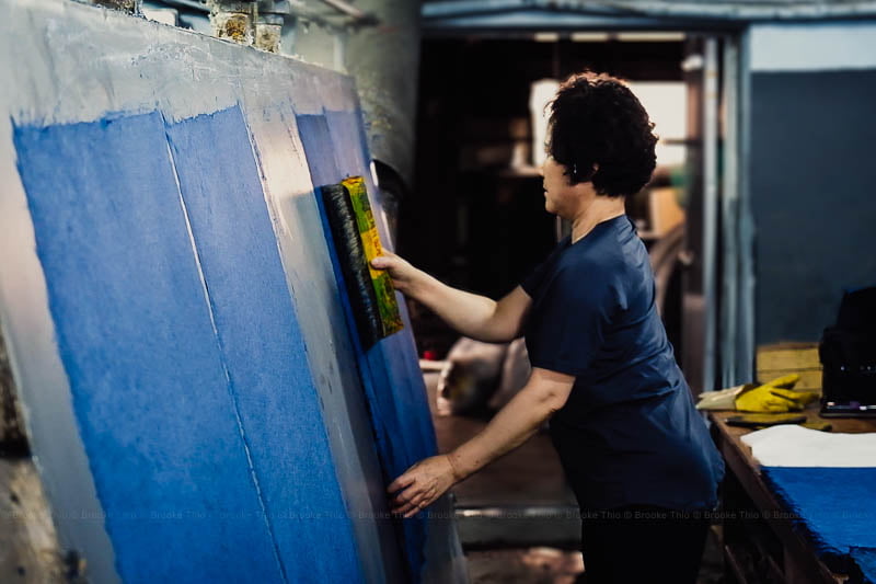 Workers dry each sheet of hanji (Korean paper) by brushing it on a warm steel board.