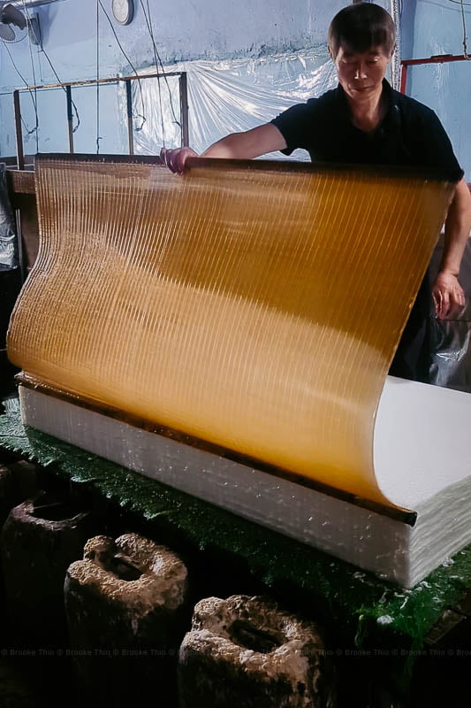 A worker peels the bamboo screen off a freshly made sheet of hanji.